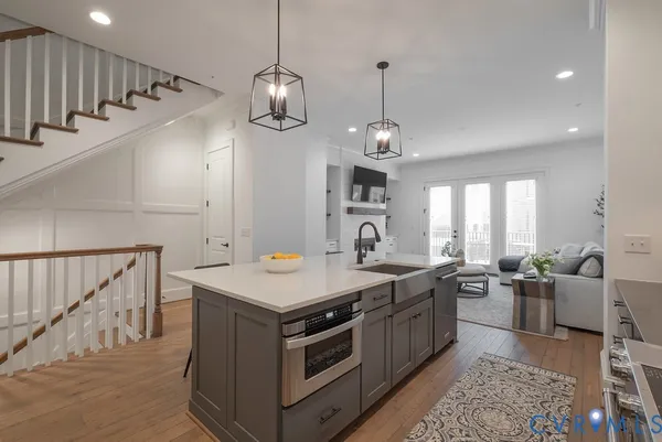 an open kitchen with a sink a counter space and stainless steel appliances