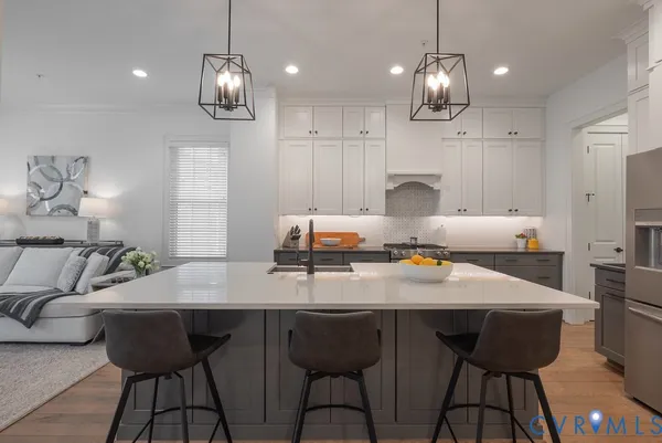 a kitchen with sink a stove and chairs