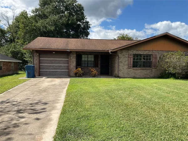 a front view of house with yard and trees in the background