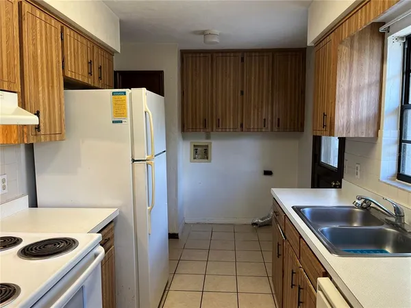 a kitchen with a refrigerator sink and cabinets