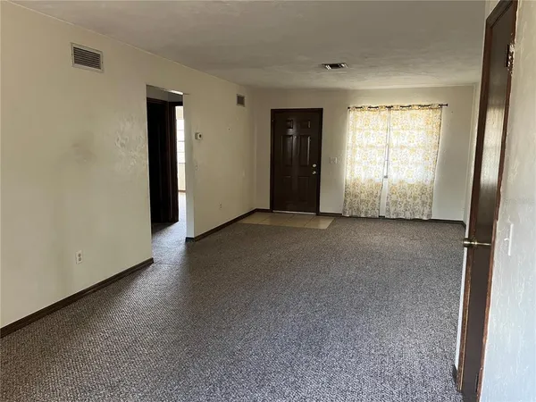 a view of a livingroom with an empty space and a window