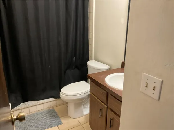 a bathroom with a sink a toilet and shower curtain