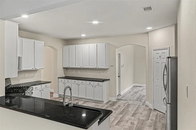 a kitchen with granite countertop a sink stainless steel appliances and cabinets