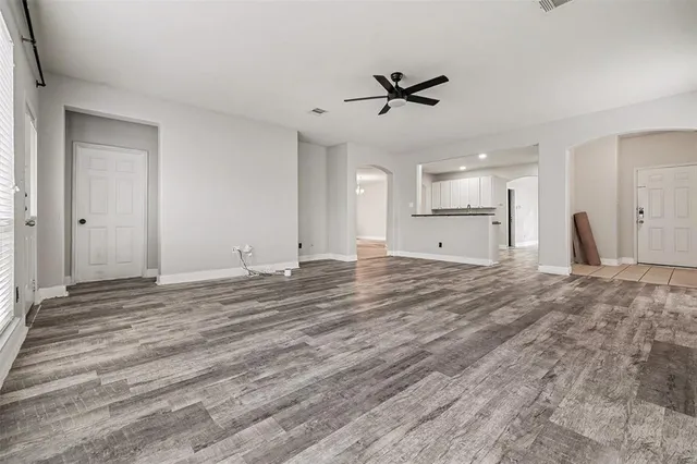 a view of an empty room and kitchen view