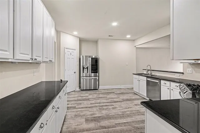 a kitchen with stainless steel appliances granite countertop a sink stove and refrigerator