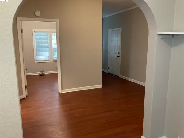 an empty room with wooden floor and a window