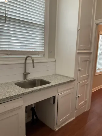 a kitchen with granite countertop a sink and cabinets