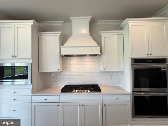 a kitchen with white cabinets and appliances