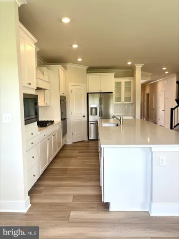 a kitchen with stainless steel appliances kitchen island granite countertop a stove and a sink
