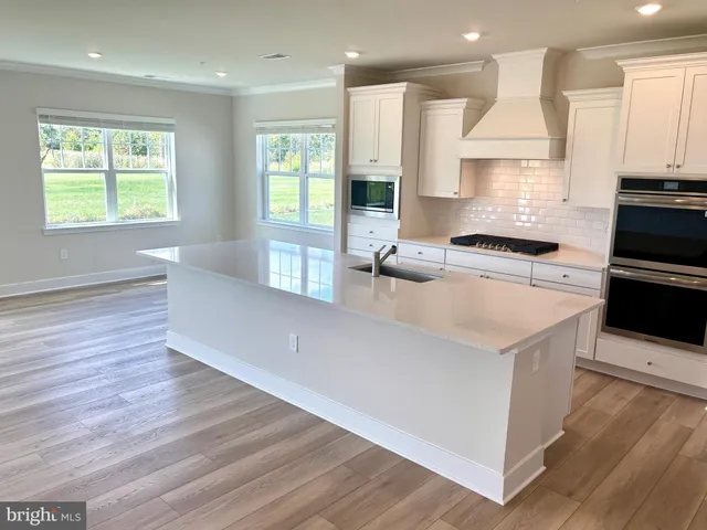 a large kitchen with stainless steel appliances granite countertop a stove a sink and a refrigerator