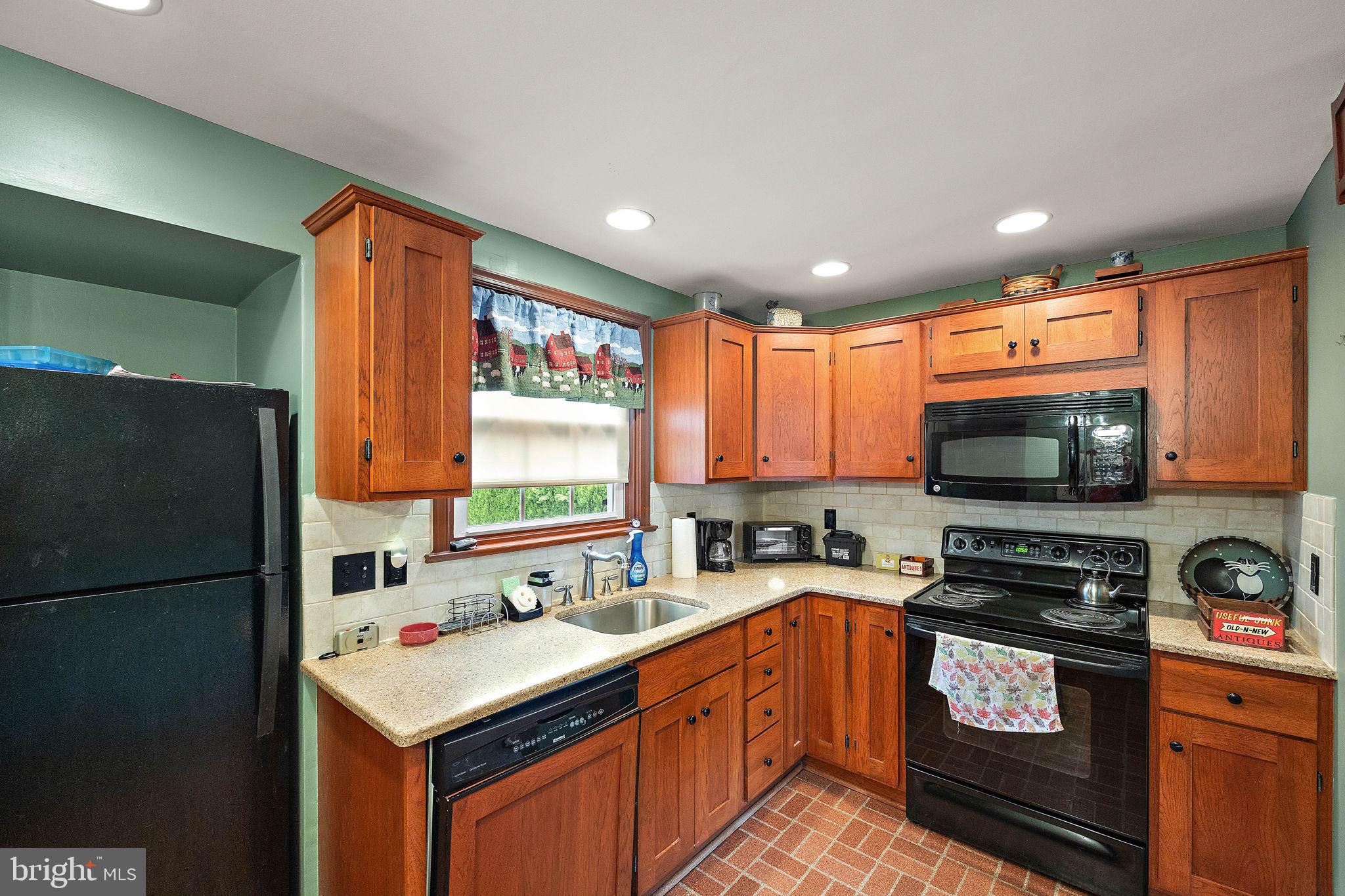 227 Pine Ridge Road Havertown, PA 19083 - Photo 14 of 36 a kitchen with stainless steel appliances granite countertop a refrigerator a sink a stove a microwave and wooden cabinets