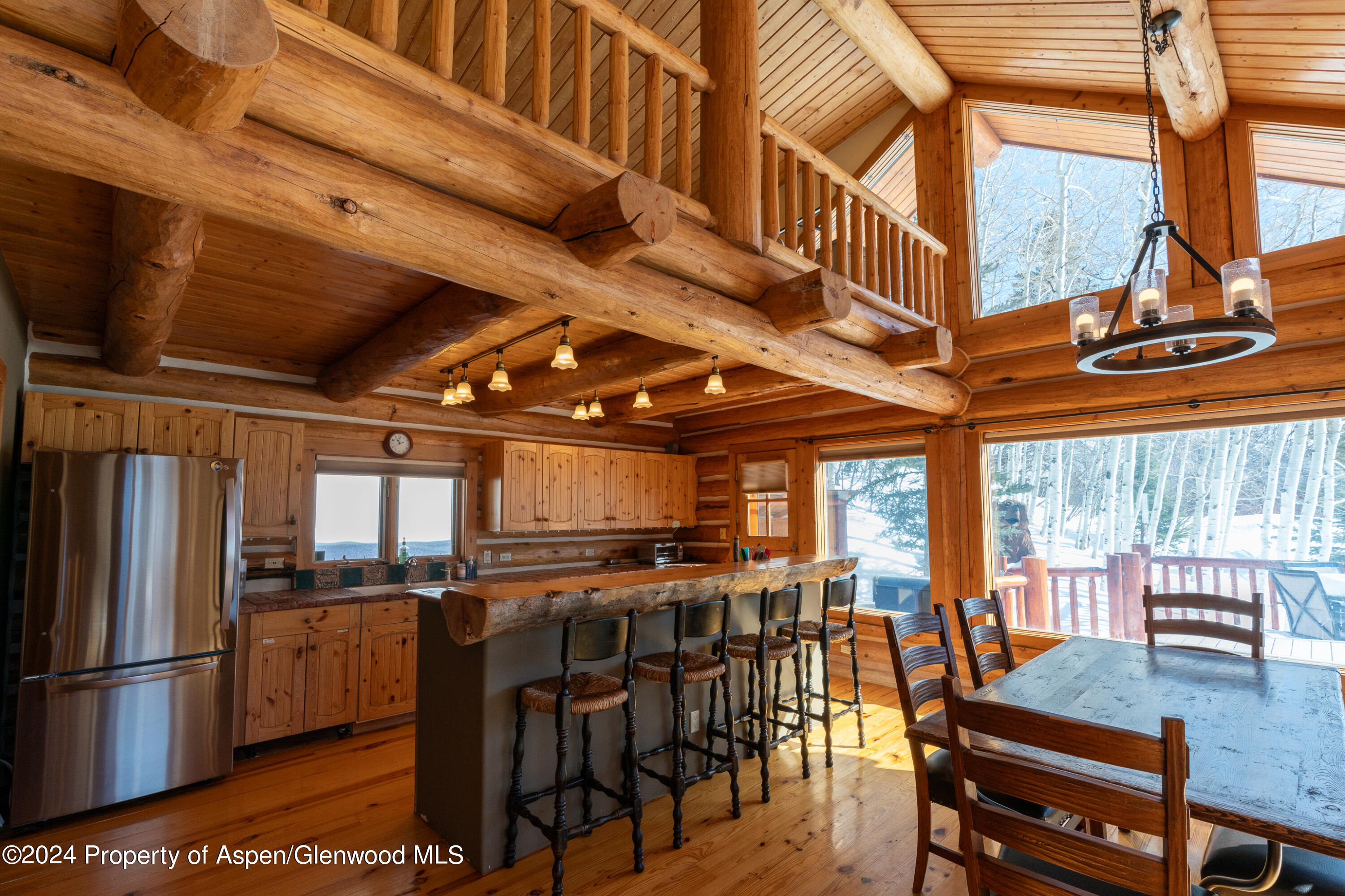 491 McLaughlin Lane Basalt, CO 81621 - Photo 4 of 56 a kitchen with stainless steel appliances kitchen island granite countertop a table chairs and a refrigerator