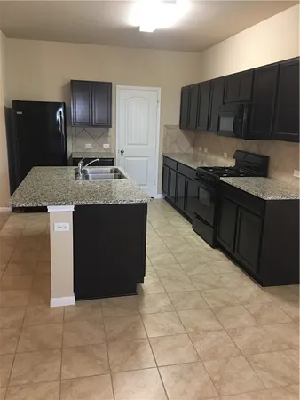 a kitchen with stainless steel appliances granite countertop a stove a refrigerator and a oven