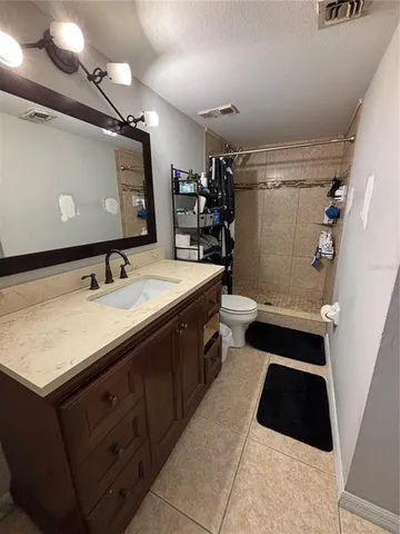 a bathroom with a sink a toilet a mirror and shower