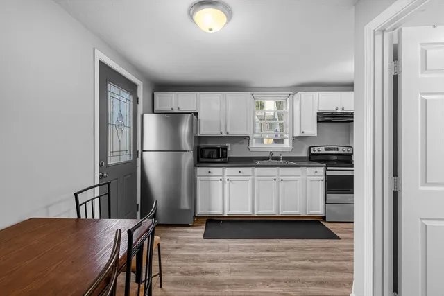 a kitchen with stainless steel appliances granite countertop a refrigerator a stove a sink and a microwave