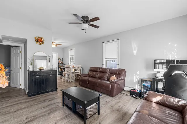 a living room with furniture and a wooden floor