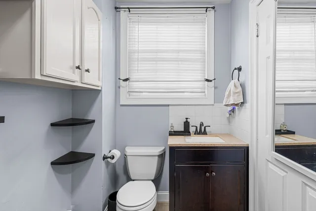 a bathroom with a sink vanity and toilet
