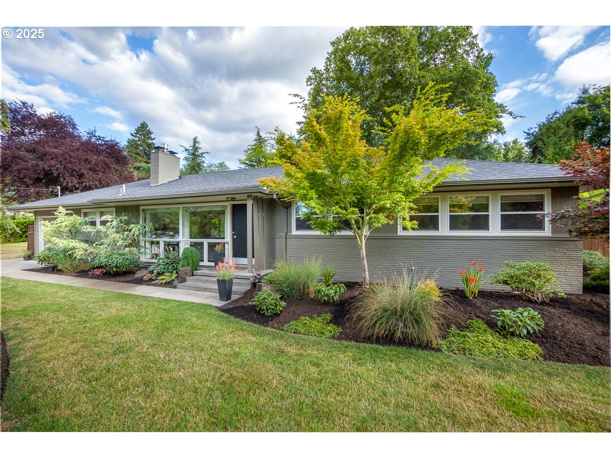 a view of a house with a yard and potted plants
