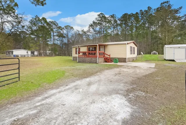 a view of a house with a yard and pathway
