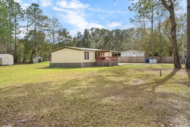 a view of a house with a yard and sitting area