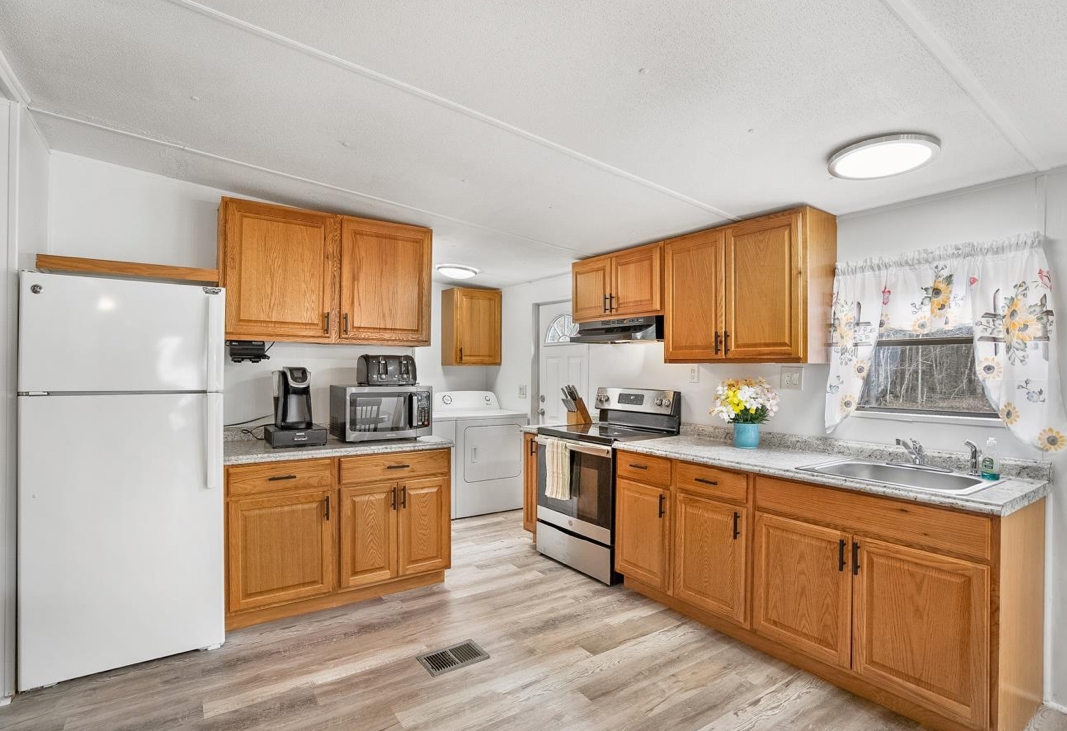 4410 Rues Landing Road St. Augustine, FL 32092 - Photo 7 of 19 a kitchen with granite countertop wooden floors stainless steel appliances a sink and a window