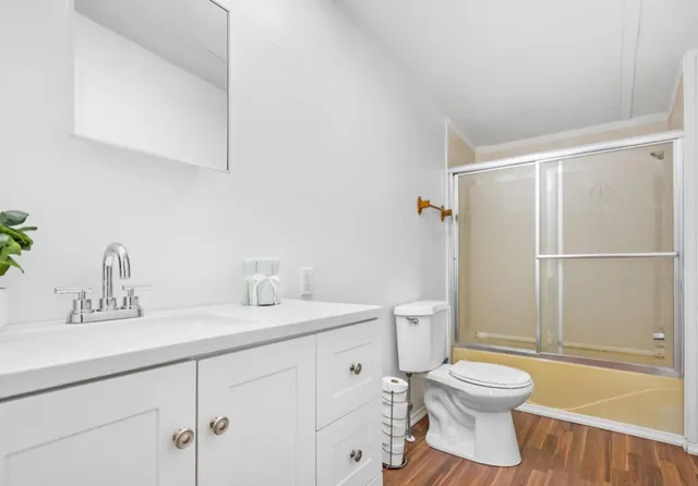 a bathroom with a sink a toilet and shower