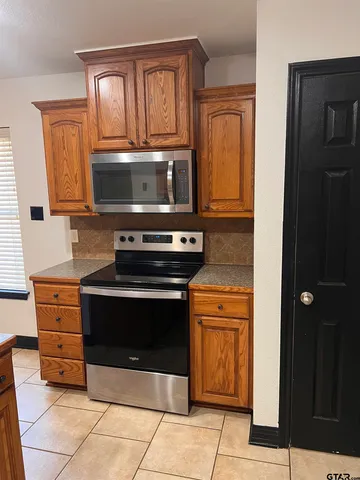 a kitchen with granite countertop a stove and a microwave