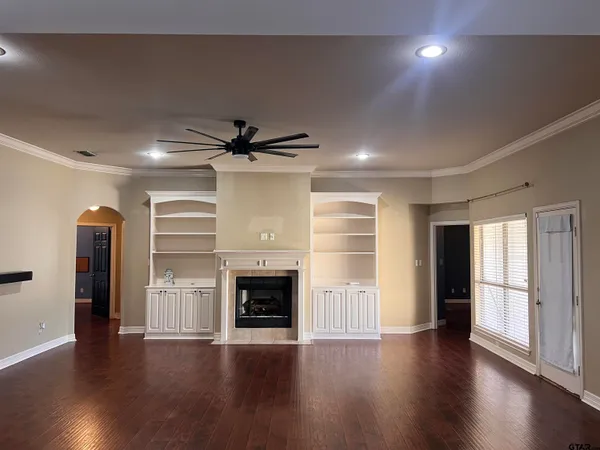 an empty room with wooden floor and fireplace