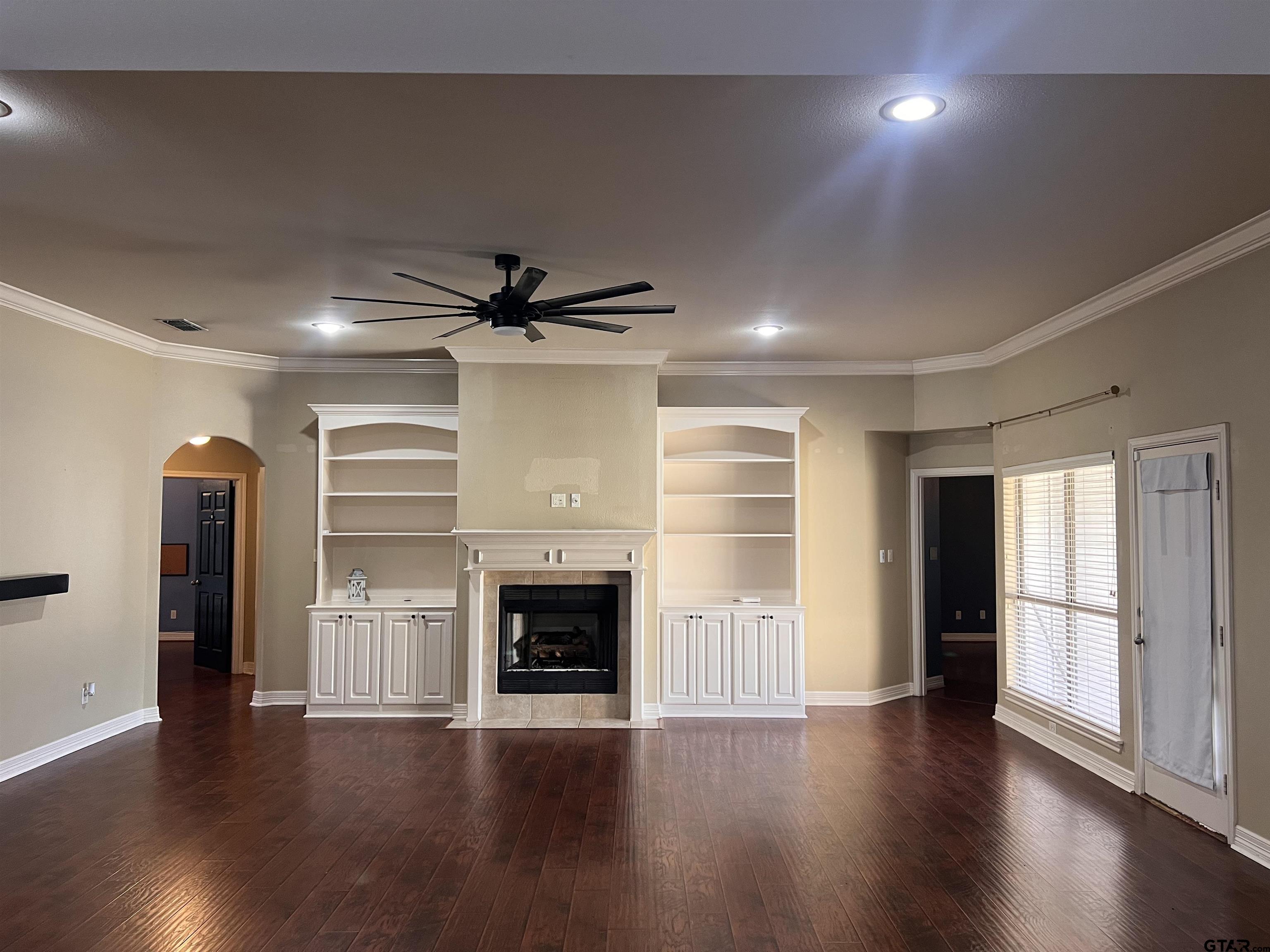 19482 Ruggles Court Flint, TX 75762 - Photo 4 of 16 an empty room with wooden floor and fireplace