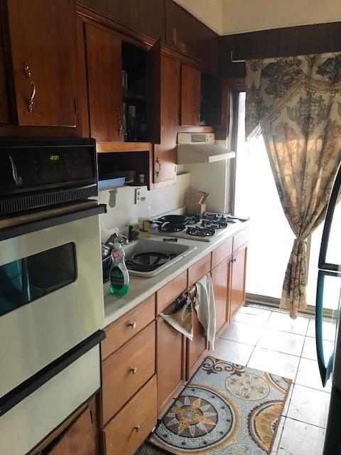 962 East 49th Street Brooklyn, NY 11203 - Photo 4 of 12 a kitchen with stainless steel appliances a stove a sink and a microwave