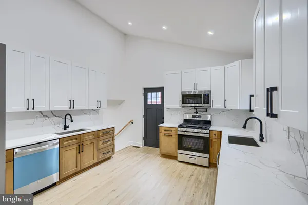 a kitchen with kitchen island stainless steel appliances a sink a stove and a center island