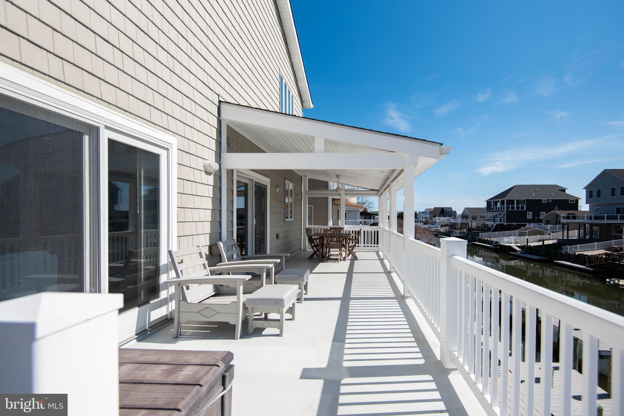 20 Edgewater Drive Tuckerton, NJ 08087 - Photo 62 of 78 a view of a patio with table and chairs with wooden floor and fence