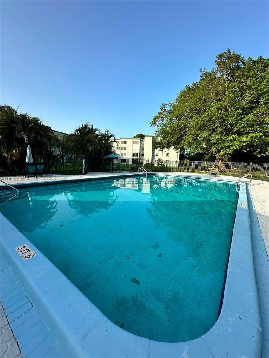 9440 Southwest 8th Street, Unit 402 Boca Raton, FL 33428 - Photo 44 of 45 a view of a swimming pool with a garden