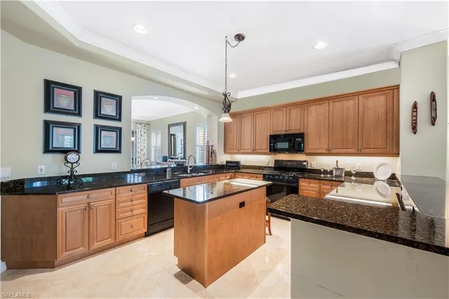 a kitchen with stainless steel appliances granite countertop a sink a stove top oven a counter space and cabinets
