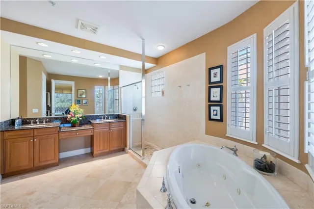 a large bathroom with a tub a sink and a large mirror