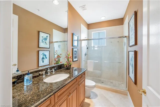 a bathroom with a granite countertop sink toilet and shower