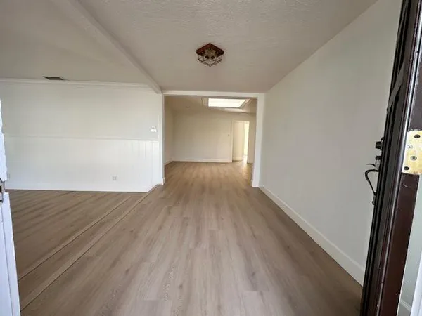 a view of a big room with wooden floor and windows