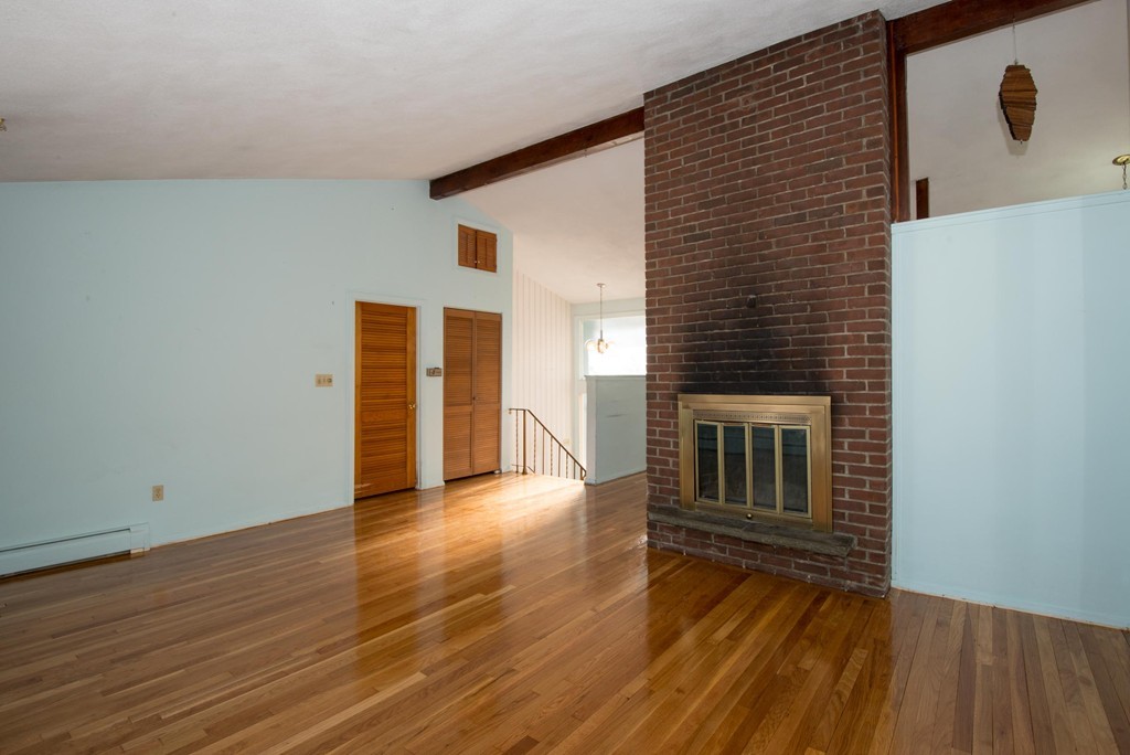 9 Fatima Road Stoneham, MA 02180 - Photo 9 of 26 a view of a livingroom with wooden floor and stairs