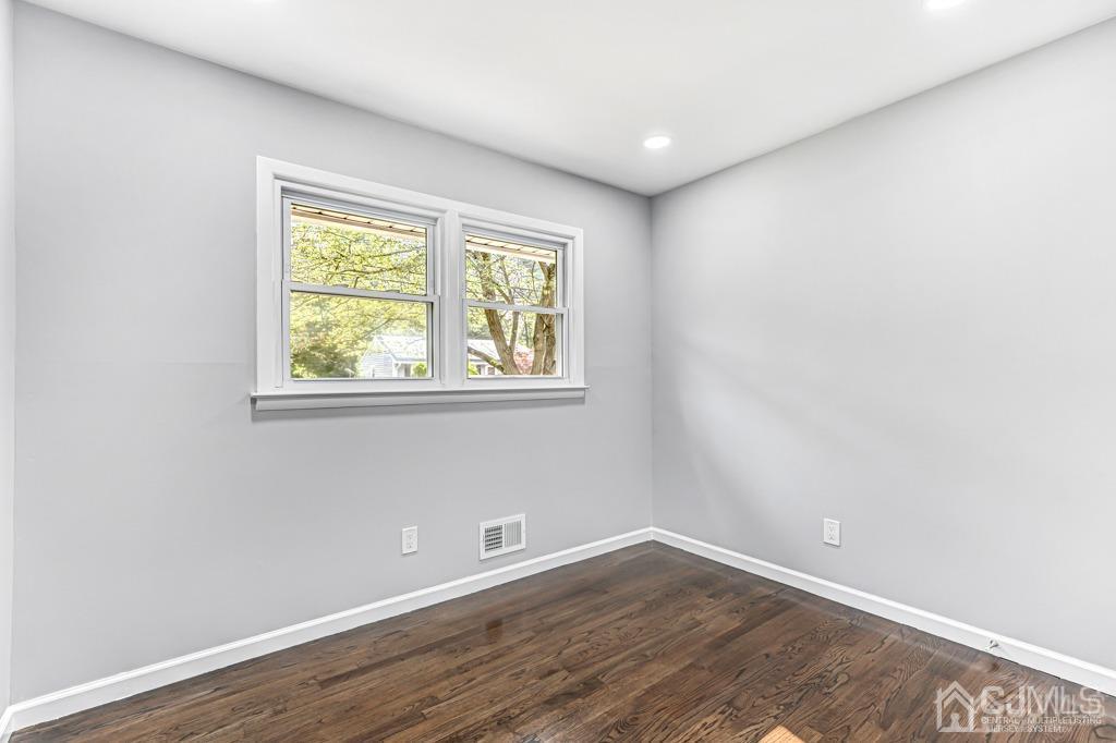 187 1st Street Middlesex, NJ 08846 - Photo 15 of 23 a view of an empty room with wooden floor and a window