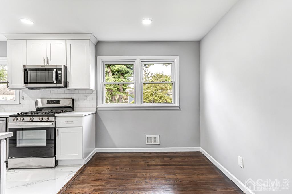 187 1st Street Middlesex, NJ 08846 - Photo 8 of 23 a kitchen with a stove a microwave and window