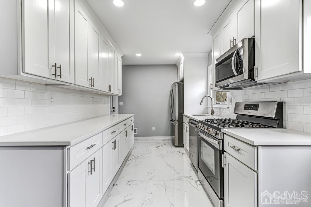 187 1st Street Middlesex, NJ 08846 - Photo 9 of 23 a kitchen with stainless steel appliances granite countertop a stove and a refrigerator