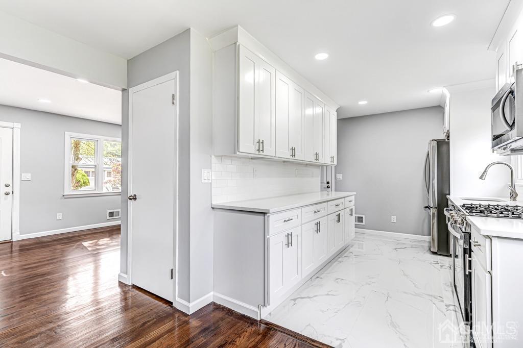 187 1st Street Middlesex, NJ 08846 - Photo 10 of 23 a kitchen with granite countertop a stove top oven sink and cabinets