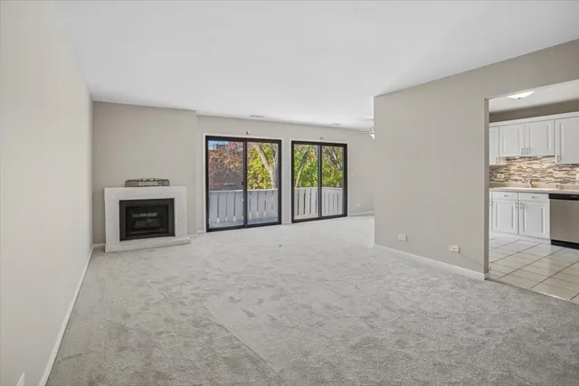 an empty room with windows and fireplace