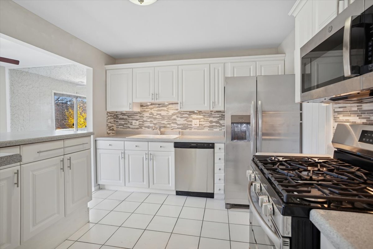 220 Hawthorne Court, Unit B2 Schaumburg, IL 60193 - Photo 7 of 20 a kitchen with white cabinets and appliances