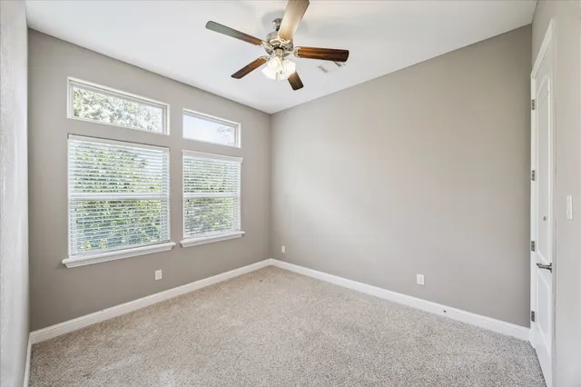 an empty room with a window and a fan