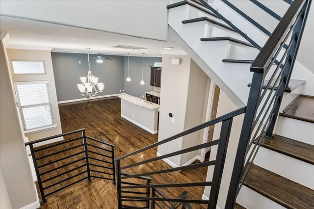 a view of an empty room with kitchen and a window
