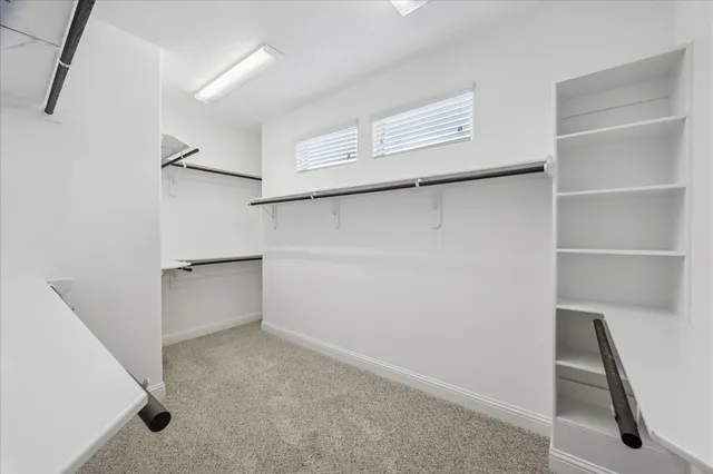 an empty room with a window and a ceiling fan