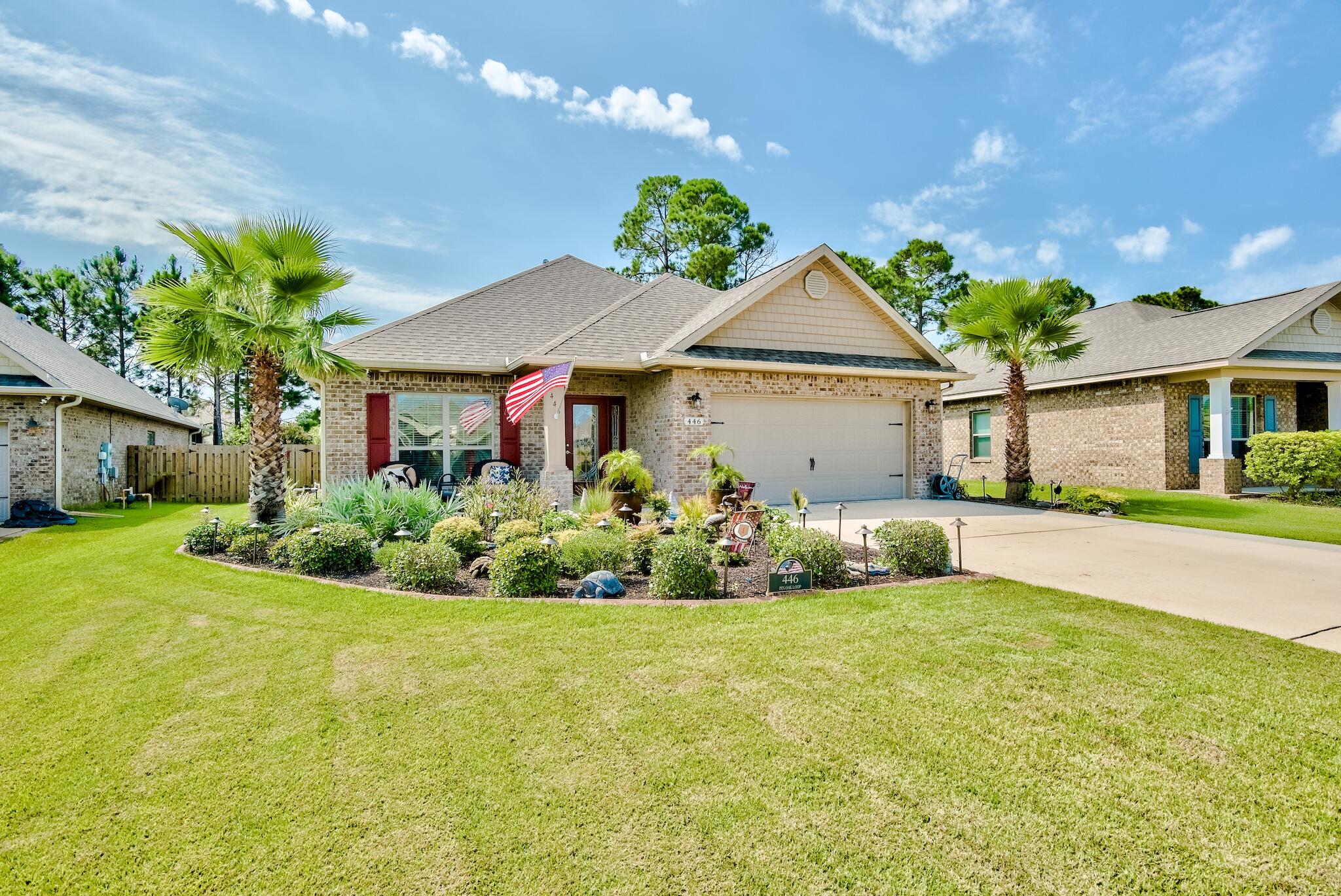 a front view of a house with a garden and plants
