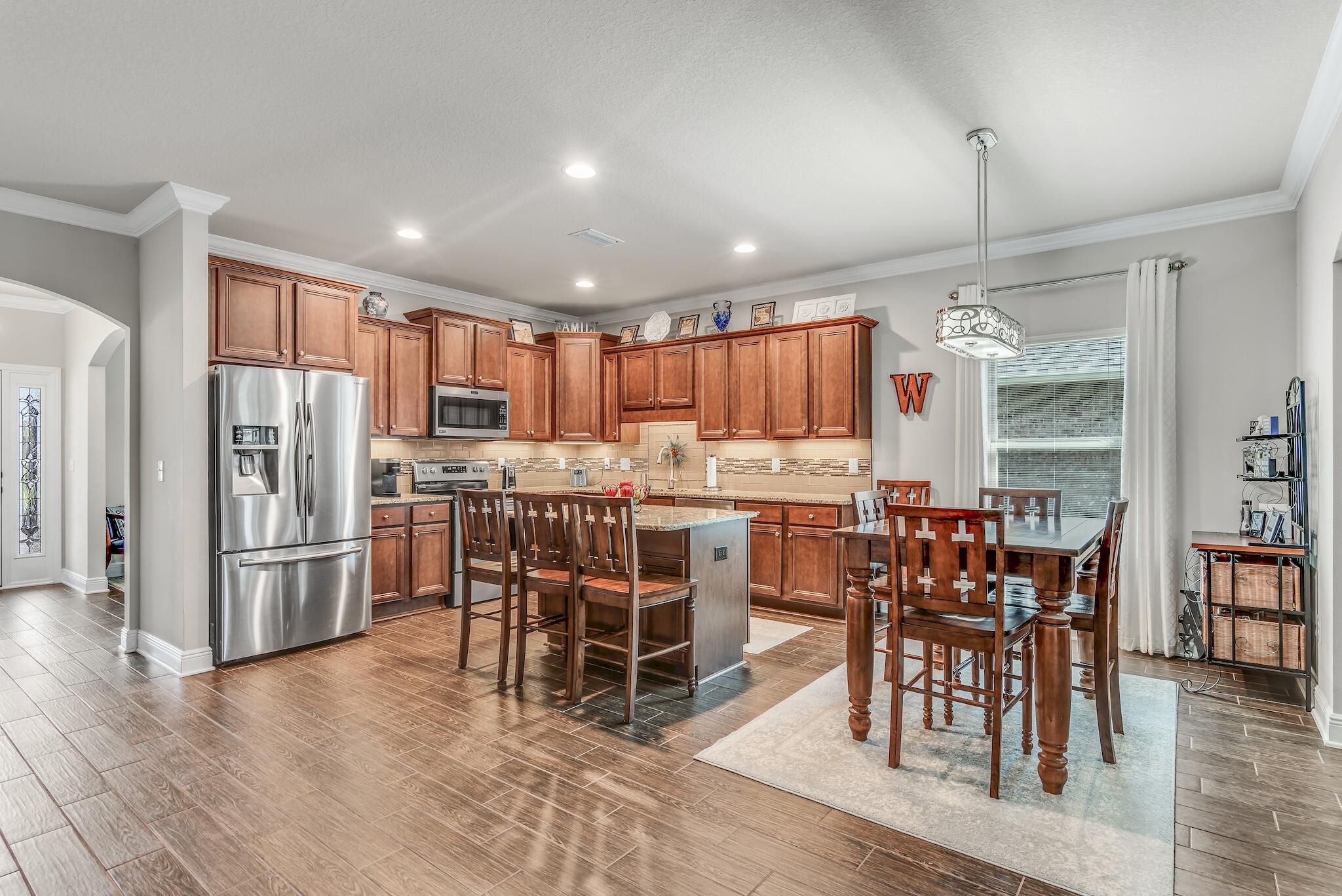 446 Pin Oak Loop Santa Rosa Beach, FL 32459 - Photo 15 of 48 a kitchen with stainless steel appliances a dining table chairs stove refrigerator and cabinets