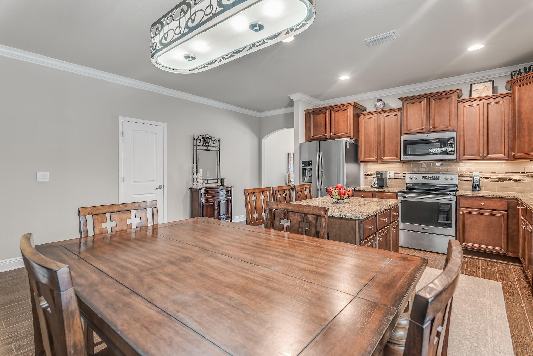 446 Pin Oak Loop Santa Rosa Beach, FL 32459 - Photo 16 of 48 a large kitchen with kitchen island a stove a sink a dining table and chairs